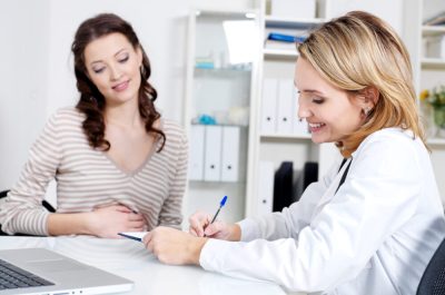 Smiling doctor and happy beautiful young woman - indoors